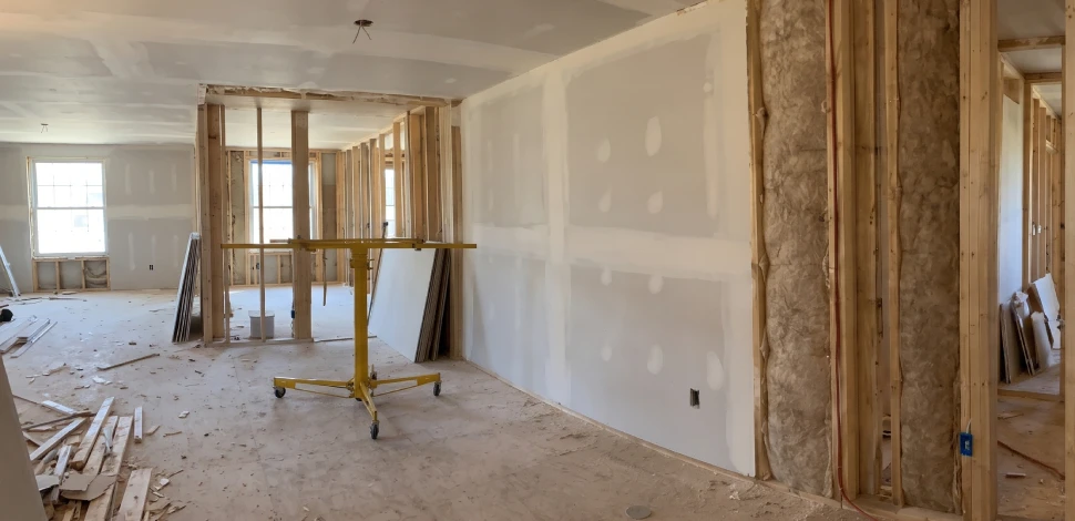 New framing and drywall going up on a wall between two apartments during a rebuild after fire